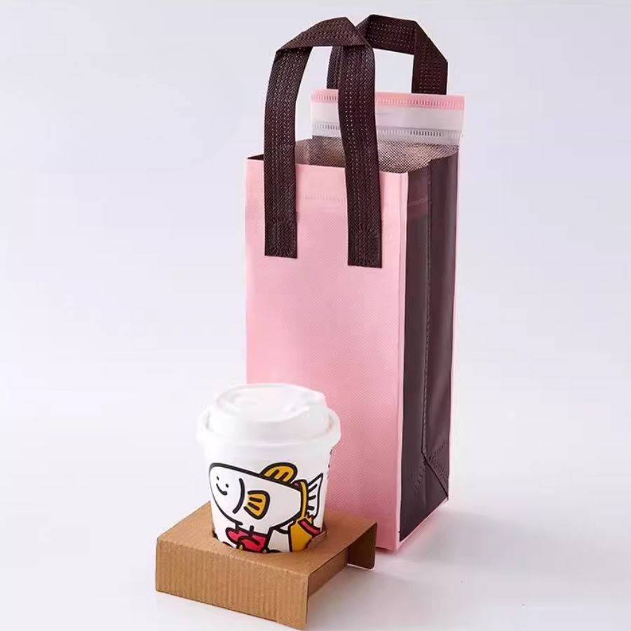 Túi giữ nhiệt 1 ly màu hồng nâu có lớp lót nhôm, đi kèm ly trà sữa minh họa, phù hợp giao hàng nhanh gọn.