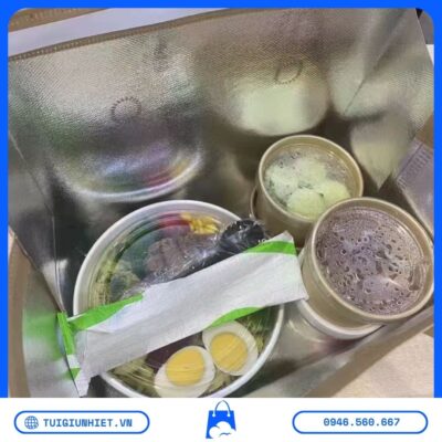 Bên trong túi giữ nhiệt trà sữa chứa đồ uống và thực phẩm mang đi, lớp lót nhôm giúp duy trì nhiệt độ ổn định trong quá trình giao hàng.